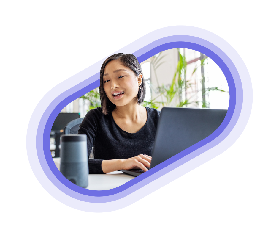 A person sitting in an office space on their laptop